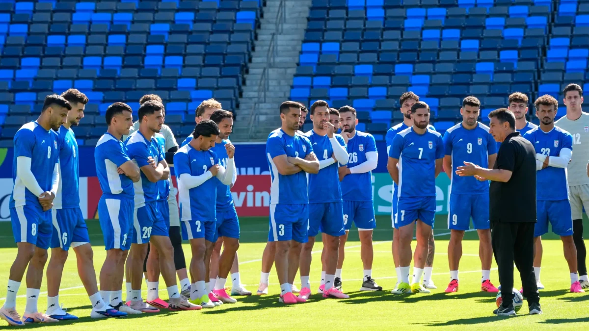 İran Milli Futbol Takımı oyuncuları, stadyumda yaptıkları antrenman sırasında teknik direktörlerinden taktik alıyor.