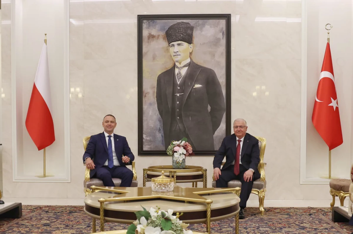 Atatürk portresi önünde, Polonya ve Türkiye bayrakları eşliğinde yan yana oturan iki devlet yetkilisi.